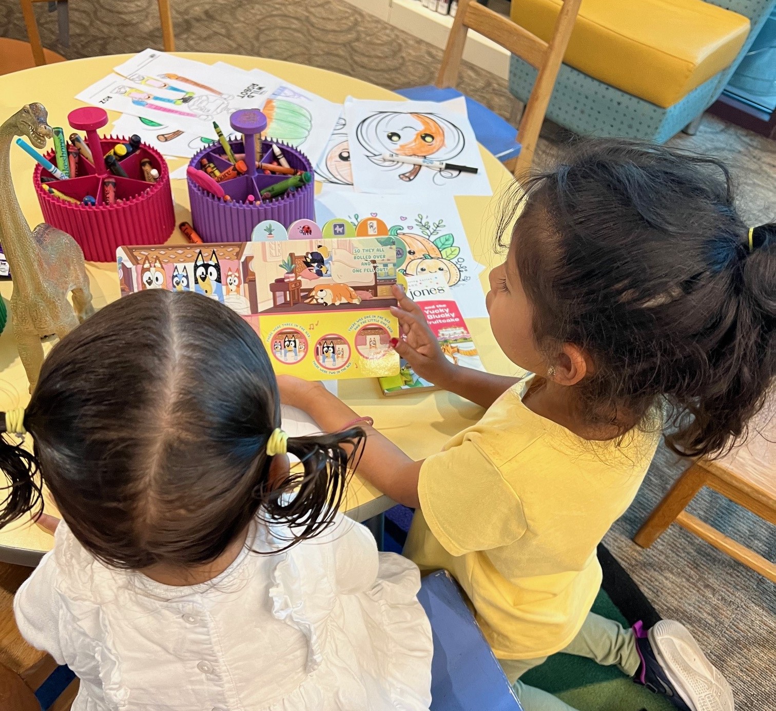two young girls reading a childen's book