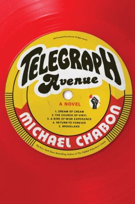 A close-up of a red vinyl record with a yellow sticker in the center reading 