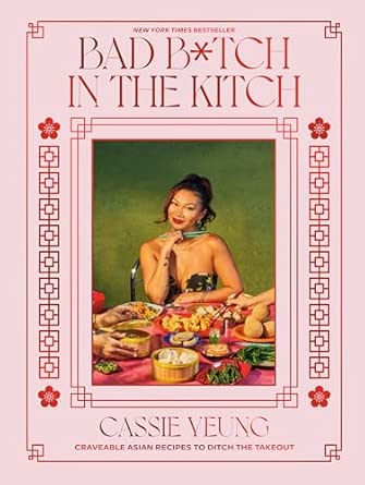 Light pink cover with ornate linework framing a photograph of an Asian woman with a brown ponytail sitting at a table covered in food.
